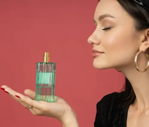 Mujer oliendo un perfume. Imágen publicitaria. Canva Images. Mujer oliendo un perfume. Imágen publicitaria. Canva Images.